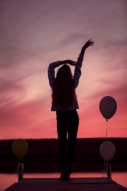 Foto bellissimo tramonto rosso con sagome di ragazza