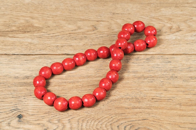 Beautiful red wooden beads lying on an old wooden table