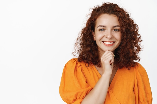 Beautiful redhead adult woman with curly hair on white.