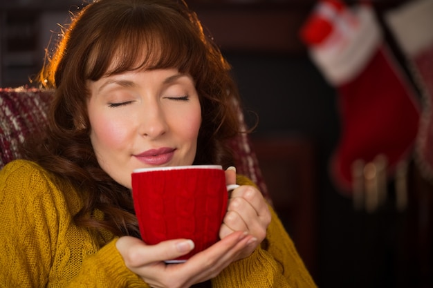 Beautiful redhead enjoying hot drink at christmas