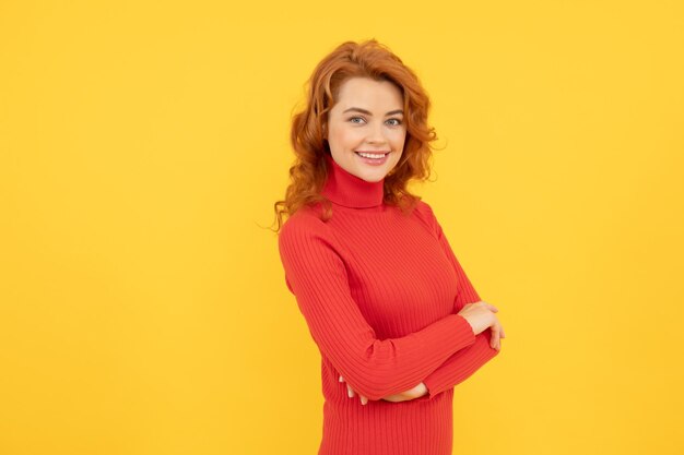 beautiful redhead girl face portrait smiling on yellow background, copy space, fashion.