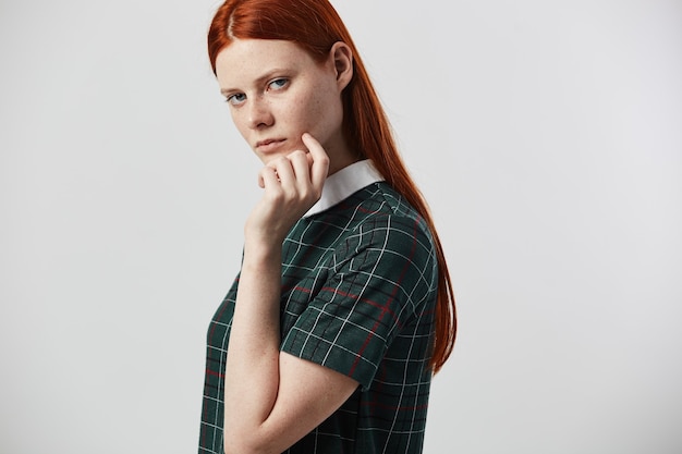 beautiful redhead long-haired girl in a green checkered dress 