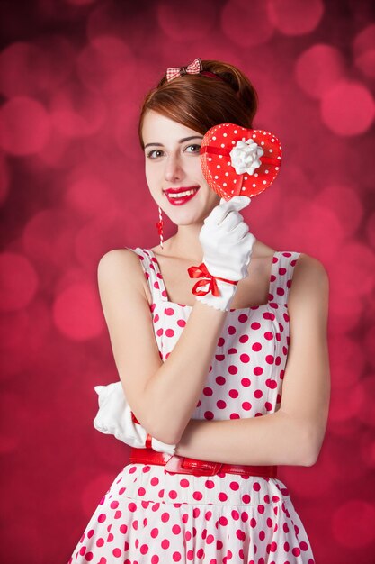 Beautiful redhead women with gift. Photo in retro style with bokeh at background.