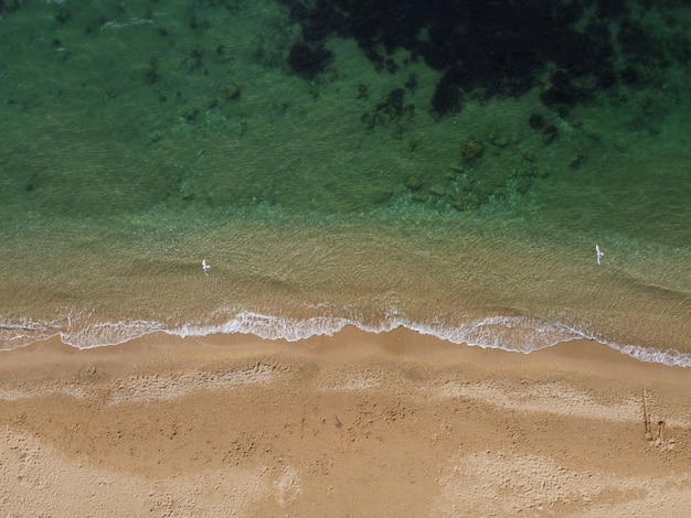 Красивый удаленный пляж с кристально чистой лазурной водой с высоты птичьего полета, нетронутая природа и скрытый песок.