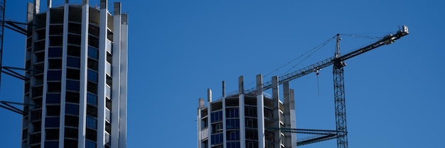 Beautiful residential buildings under construction outdoors and construction crane construction