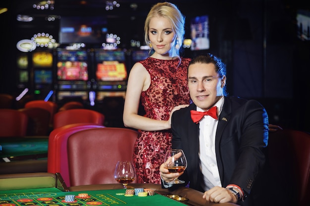 Beautiful and rich couple playing roulette in the casino