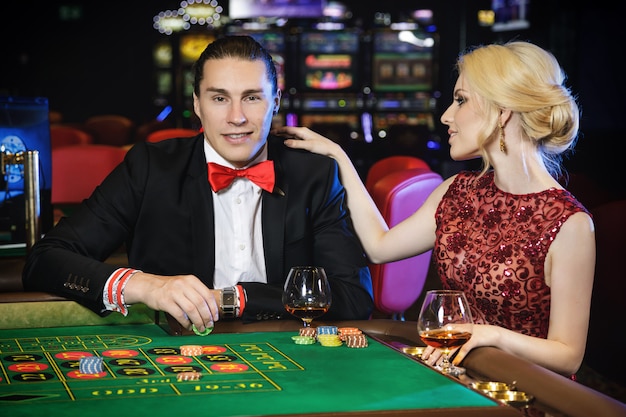 Beautiful and rich couple playing roulette in the casino