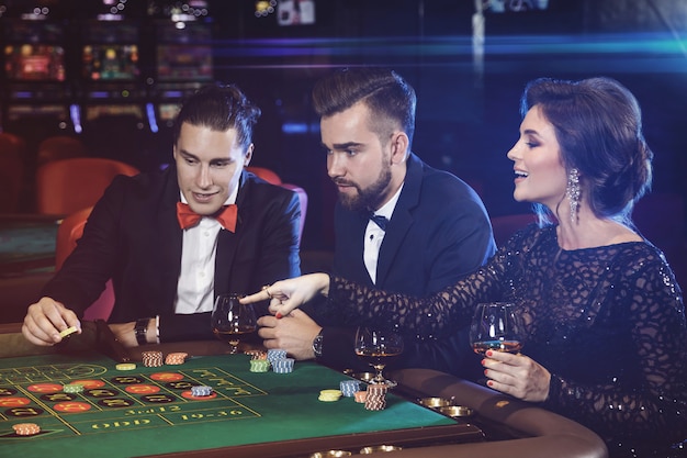 Persone belle e ricche che giocano alla roulette nel casinò