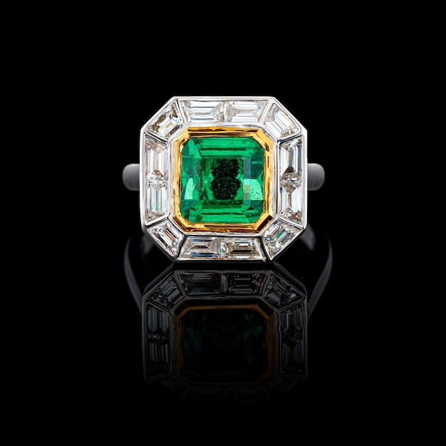 Beautiful ring made of gold with precious stones emerald and diamonds on a black background