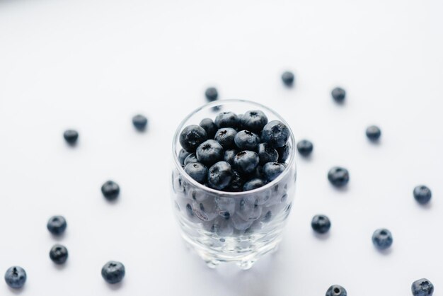 Beautiful ripe blueberries in a transparent glass glass on a white background. Healthy food, and vitamins.