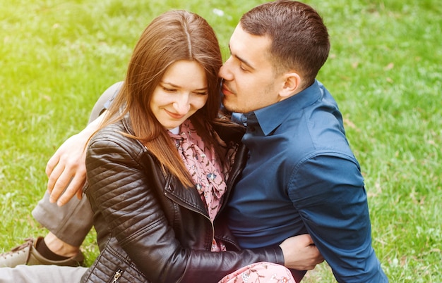 Beautiful romantic couple embracing at spring green park