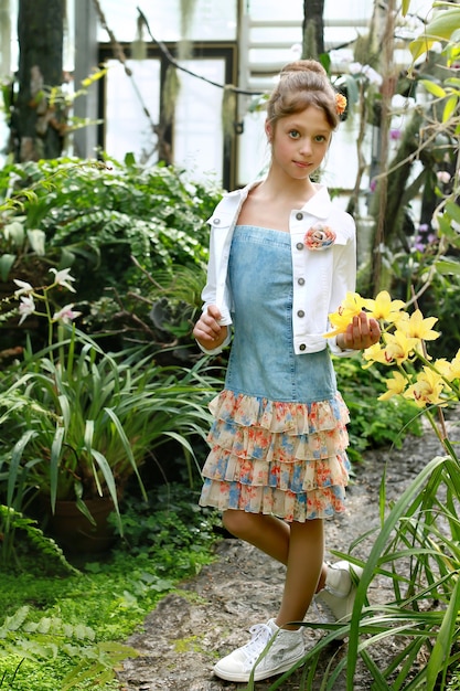 Photo beautiful romantic young  girl in a greenhouse with azaleas