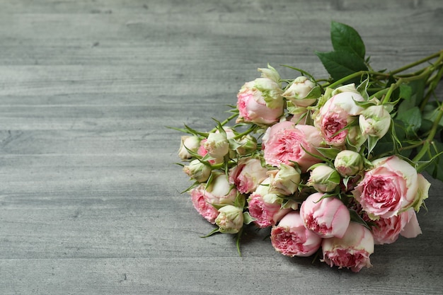 Beautiful rose flowers on gray textured background