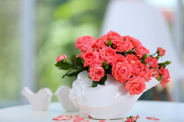 部屋のテーブルの上に花瓶の美しいバラ