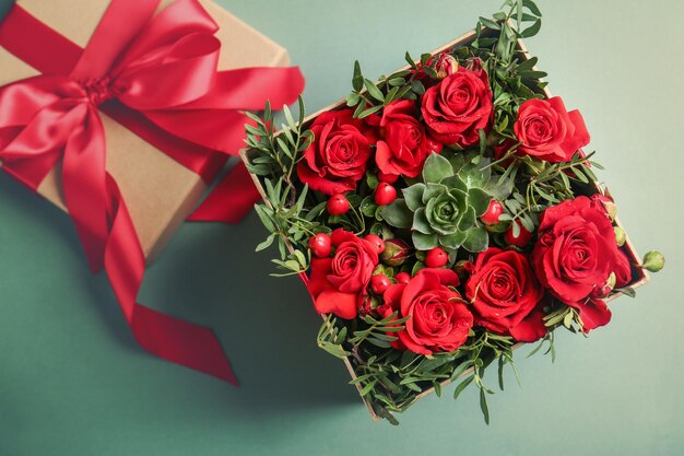 Beautiful roses in gift box on color background