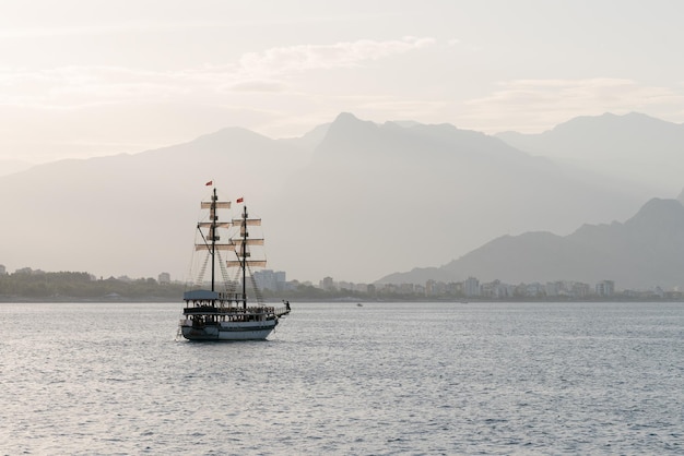 Beautiful sailing ship in the sea on a background of mountains