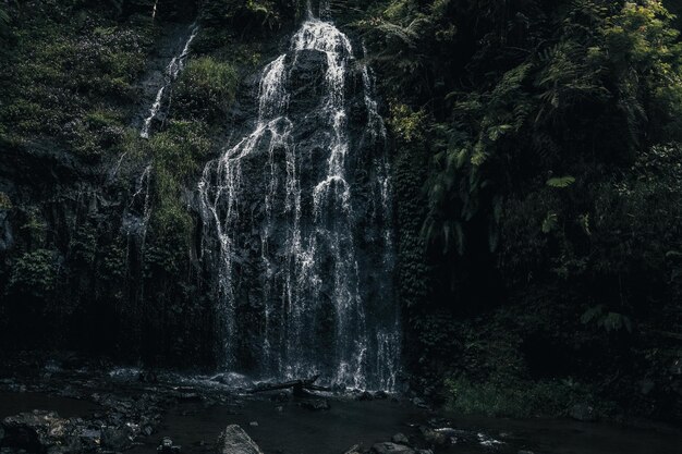 Beautiful scene of waterfall with rocks and foliage in the river at West Java Indonesia