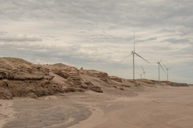 Beautiful scenery of a sandy beach with rocks with a cloudy sky