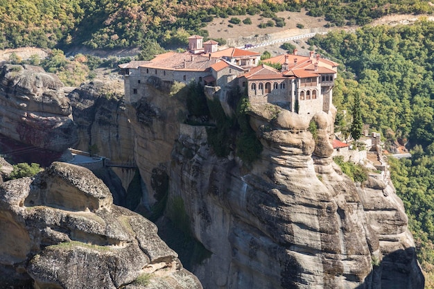 메테오라 핀도스 산맥 테살리아 그리스 유럽(Meteora Pindos Mountains Thessaly Greece Europe)의 돌담 배경에 있는 아름다운 Varlaam 정교회 수도원(Orthodox Monastery of Varlaam) 거대한 모놀리식 기둥 녹색 잎사귀