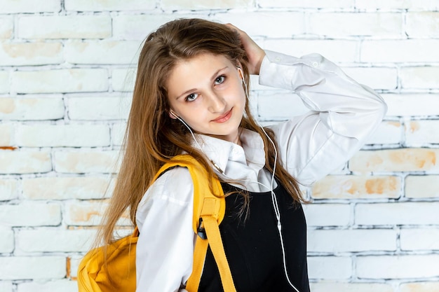 Beautiful school girl in a uniform stands on white background