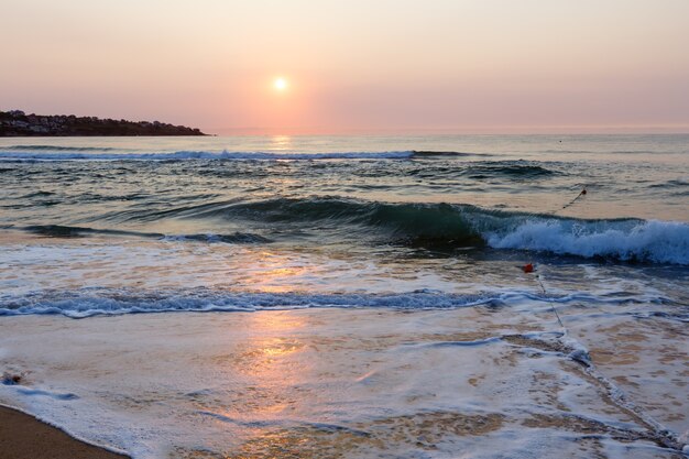 水に太陽の反射と美しい海のビーチの日の出の景色。