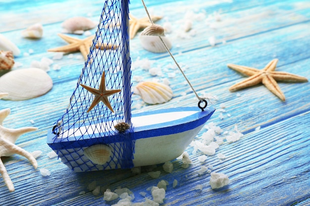 Красивая морская композиция с лодкой и ракушками на деревянных фоне
