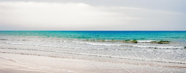 Foto splendida vista sulla costa dell'orizzonte del mare o dell'oceano dal viaggio e dalla destinazione delle vacanze estive della spiaggia di sabbia tropicale