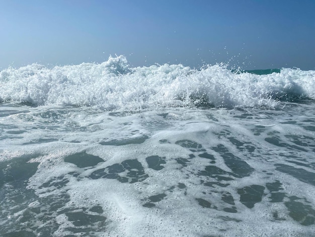 Красивое море с волнами, плещущими теплую сверкающую чистую голубую воду в теплом тропическом востоке