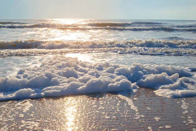 Красивый морской пейзаж. Синее море с волнами и лучами солнца на закате.