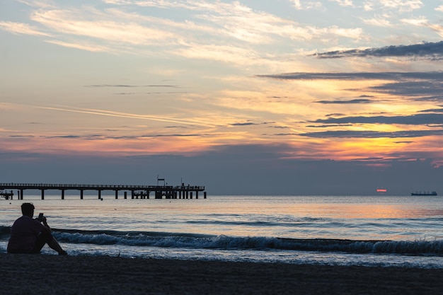 Bellissimo paesaggio marino con un ponte al tramonto