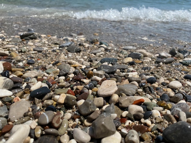 Beautiful seashore with small waves and colored stones