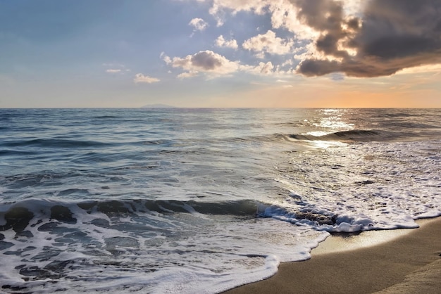 Bellissimo paesaggio balneare all'alba sotto il cielo nuvoloso