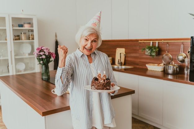 Beautiful senior couple celebrating  anniversary with birthday cake - Elderly couple having birthday party at home