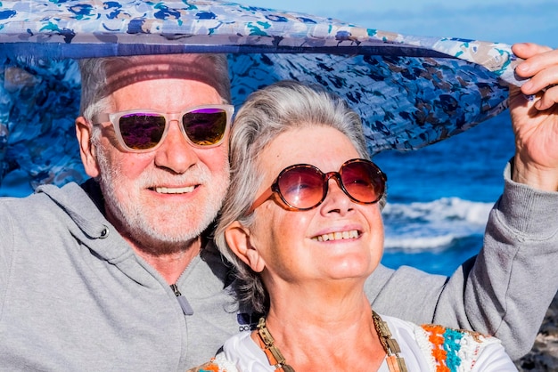 Прекрасная старшая пара моделей наслаждается солнечным светом на лицах во время каникул