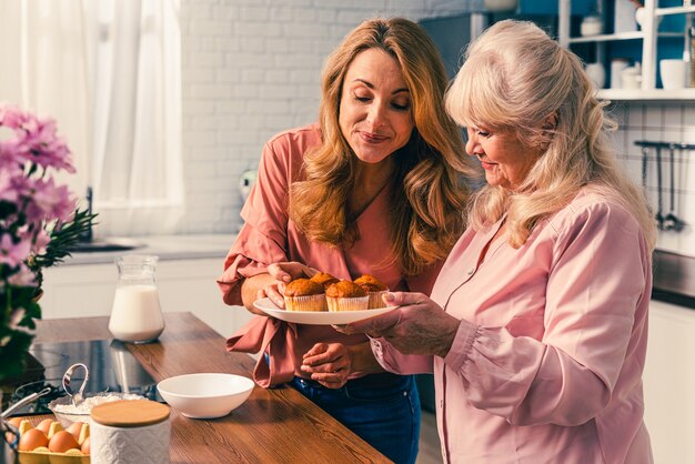 Beautiful senior woman and daughter baking in the kitchen