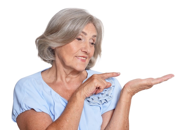 Beautiful senior woman showing something isolated on white background