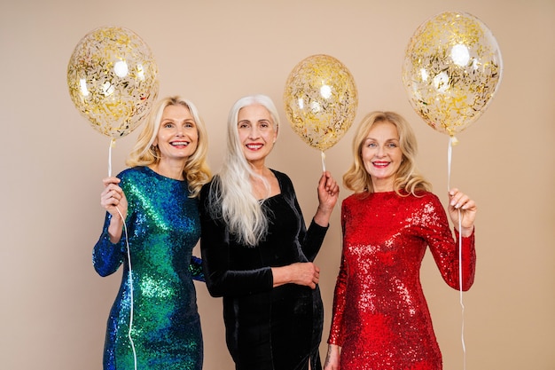 Beautiful senior women with festive elgant dress having fun at a party