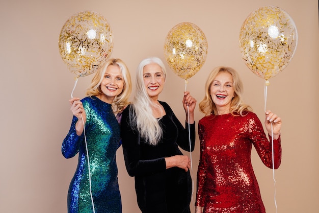 Beautiful senior women with festive elgant dress having fun at a party