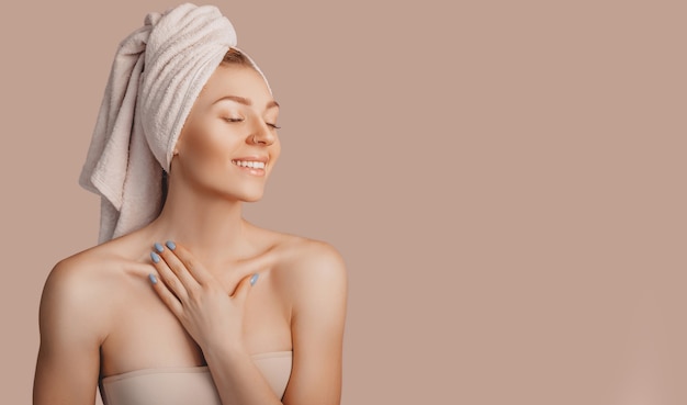 beautiful sensual young girl with clean skin on a beige wall