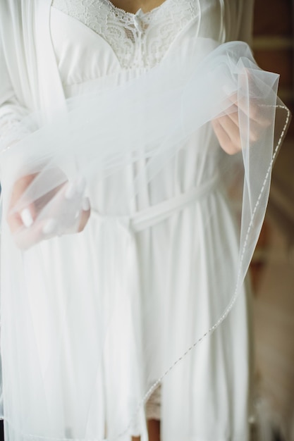 Beautiful sexy bride in white dress posing under curtain