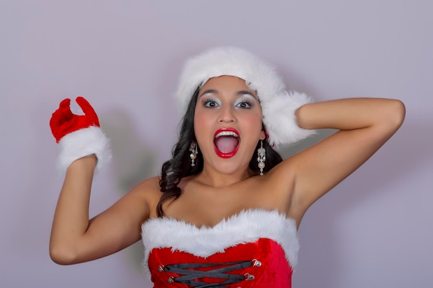 Beautiful and sexy brunette with gloves hat and Santa Claus dress with fun and friendly expression