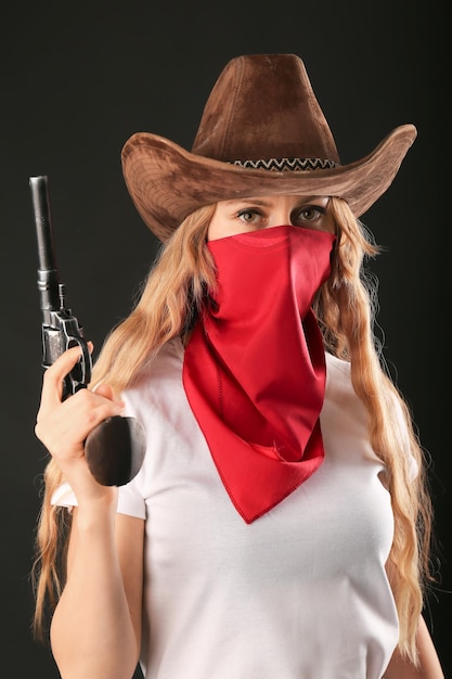 Фото Красивая сексуальная девушка ковбой в шляпе с пистолетом с местом для текста опасная девушка с оружием крупного плана брутальная красивая девушка в стиле дикого запада
