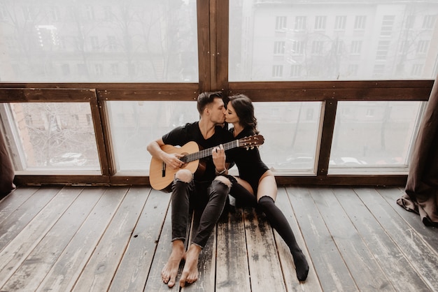 Beautiful sexy girl and her boyfriend playing guitar