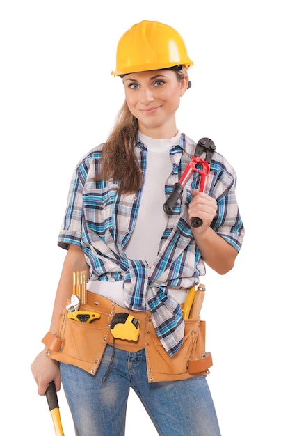 Beautiful sexy girl in work wear holding tools isolated on white background