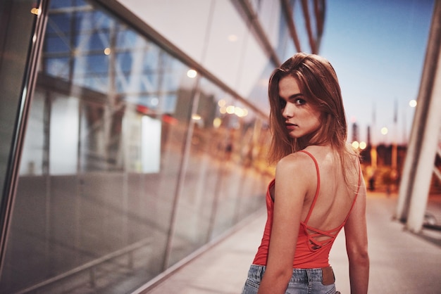 Beautiful sexy tourist girl walking in busy city street near the airport.