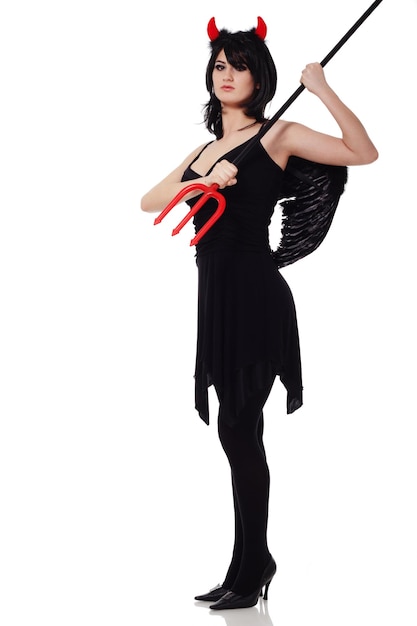 Foto una bella donna sexy in un costume da diavolo un demone con le corna e forconi un tridente in un vestito rosso abito americano per una festa in maschera halloween girocollo sul collo trucco luminoso