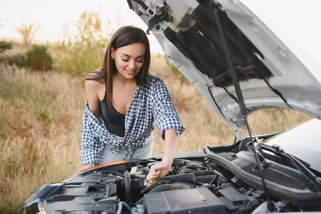 Foto bella donna sexy vicino a un'auto rotta donna confusa non sa cosa fare