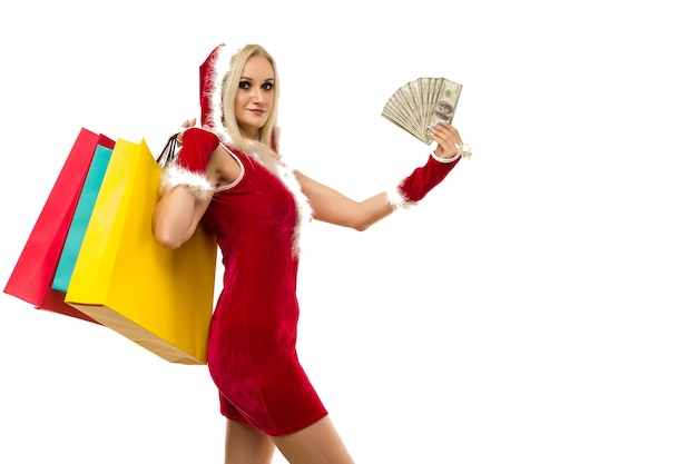 A beautiful sexy woman in a New Year's dress hold in hands money and shopping bags isolated on white Celebration of Christmas or new year sale