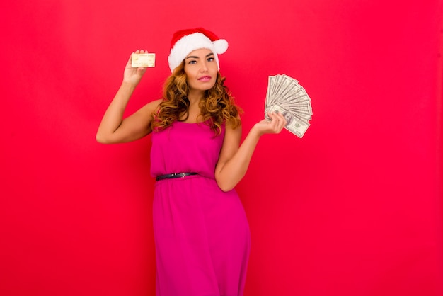 A beautiful sexy woman in a new years hat hold in hands money and credit card