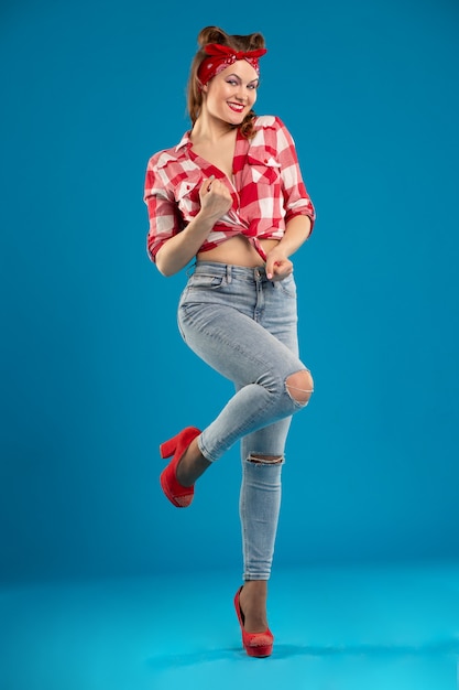 Beautiful sexy woman in the style of Pin-Up knotted on an unbuttoned plaid shirt